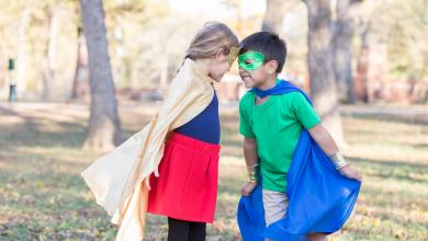 小学时代男孩和女孩假装是超级英雄和恶棍。